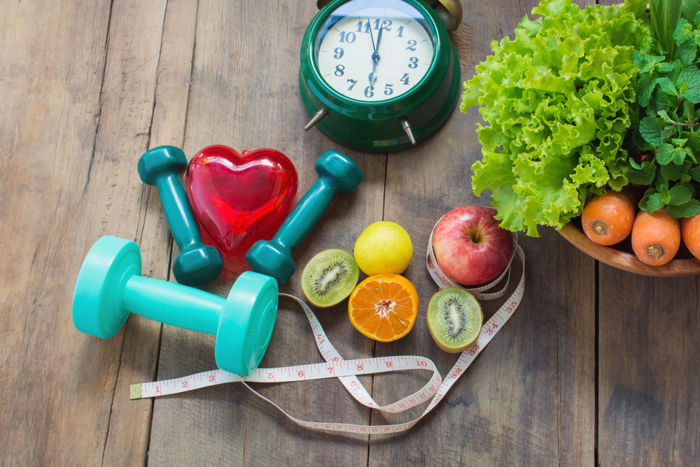 Red heart, healthy foods, Measuring tape and alarm clock on wooden background