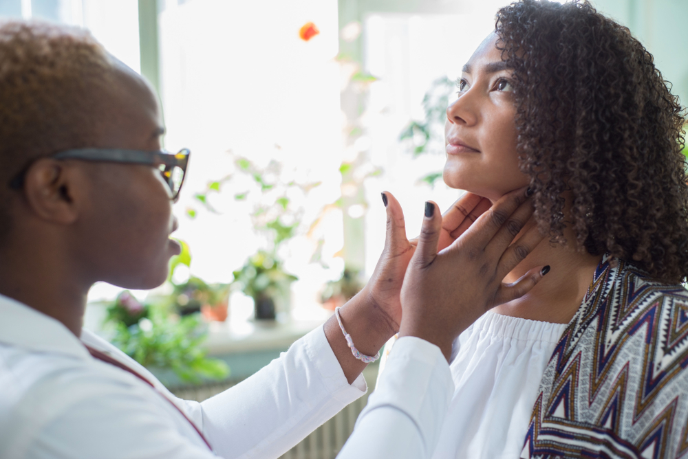 Woman getting her thyroid glands checked by doctor