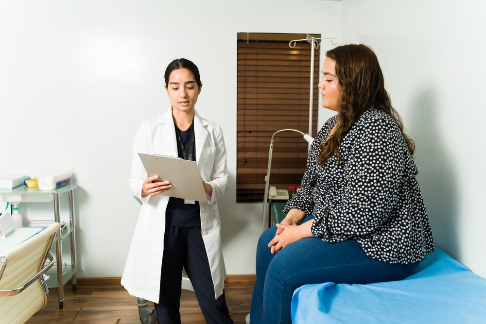 doctor checking the lab results of an overweight young woman